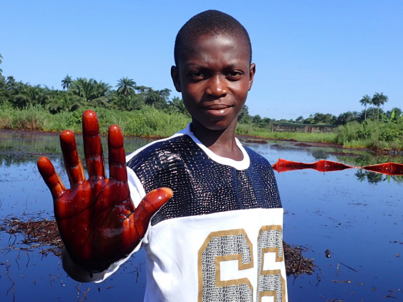 Boy holding palm covered in oil in Nigeria