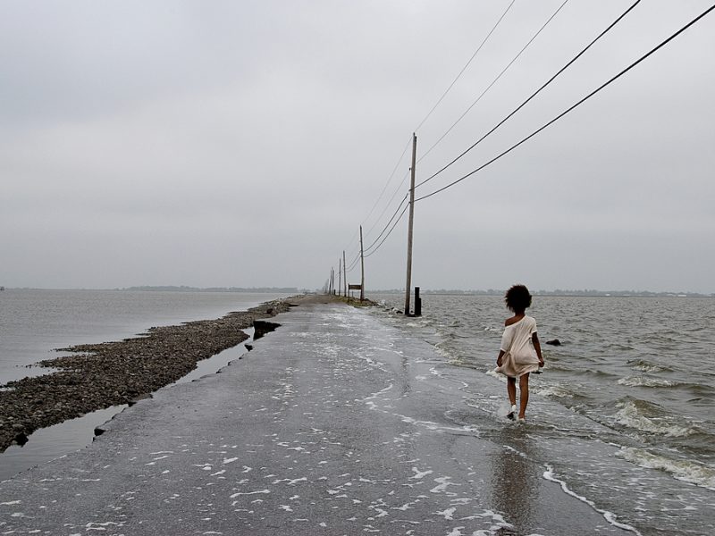 Person walking along a ruined flooded road
