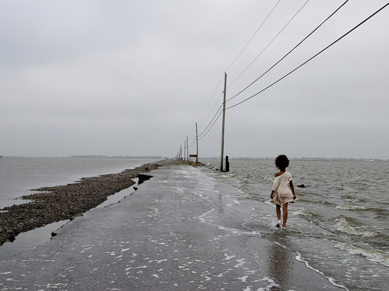 Person walking along a ruined flooded road