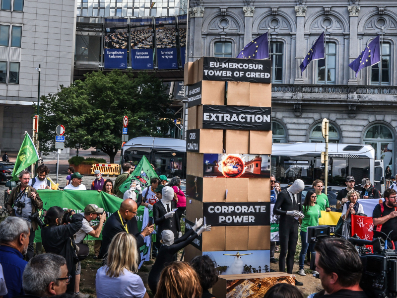 Parallel to the start of the EU-CELAC Summit, activists built and tore down a giant “EU-Mercosur Greed Jenga Tower” in front of the European Parliament, calling on policy-makers to stop the EU-Mercosur trade deal. (c) Johanna de Tessieres/Greenpeace