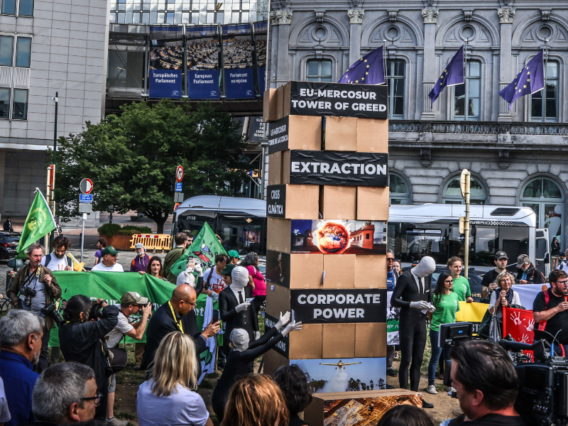 Parallel to the start of the EU-CELAC Summit in July 2023, activists built and tore down a giant “EU-Mercosur Greed Jenga Tower” in front of the European Parliament, calling on policy-makers to stop the EU-Mercosur trade deal. (c) Johanna de Tessieres/Greenpeace