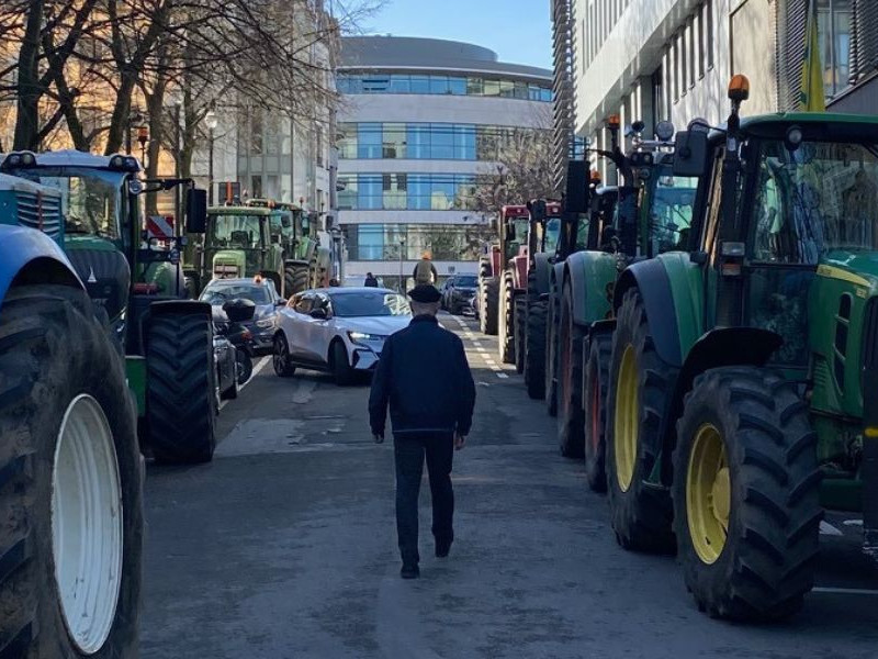 Tractors parked in the strees of Brussels, on one of them there is a placard that says in French 